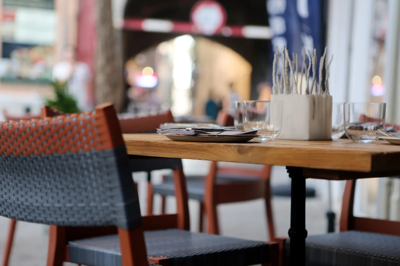 A restaurant table set on a sunny pavement