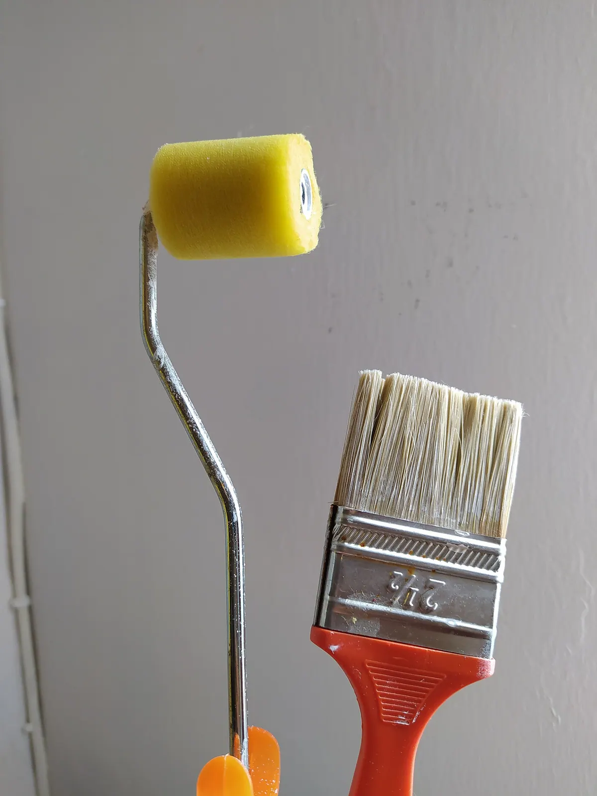 A paintbrush and a roller