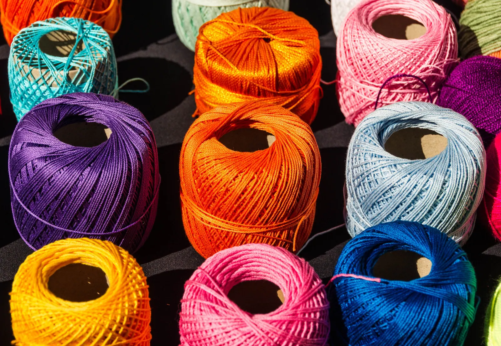 Bobbins of coloured thread on a shelf