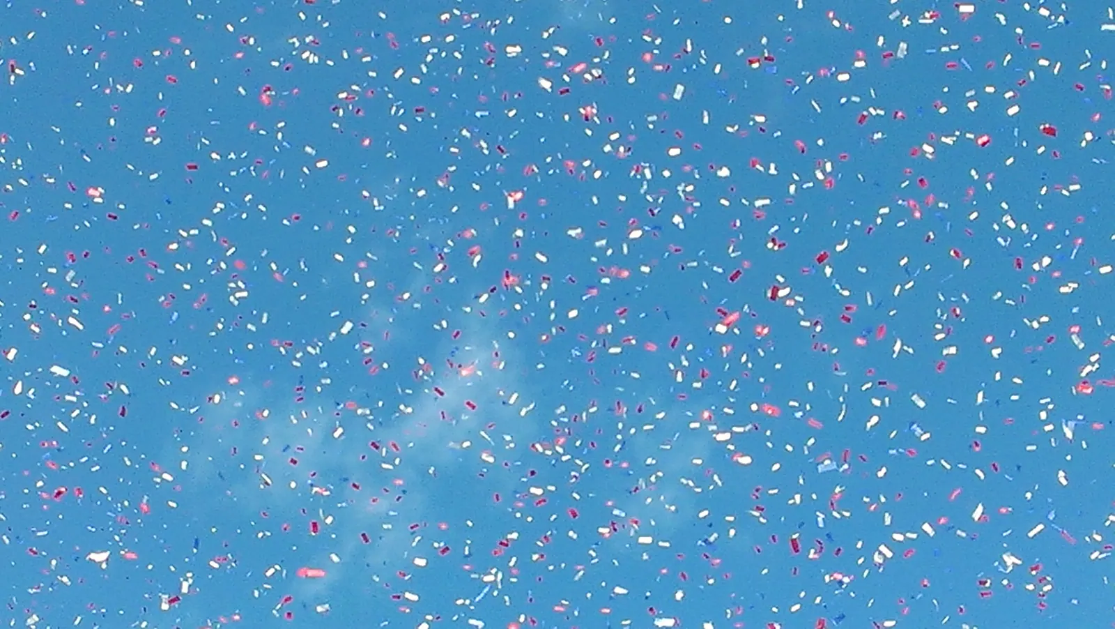 Confetti falling against a blue sky
