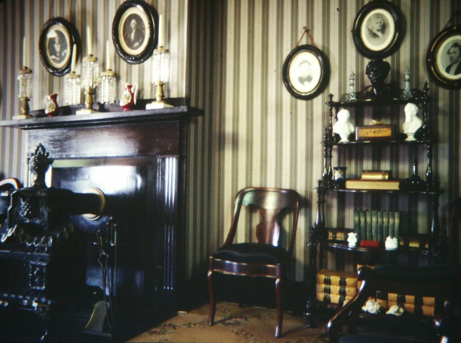 A living room with a sofa, armchairs and tall windows