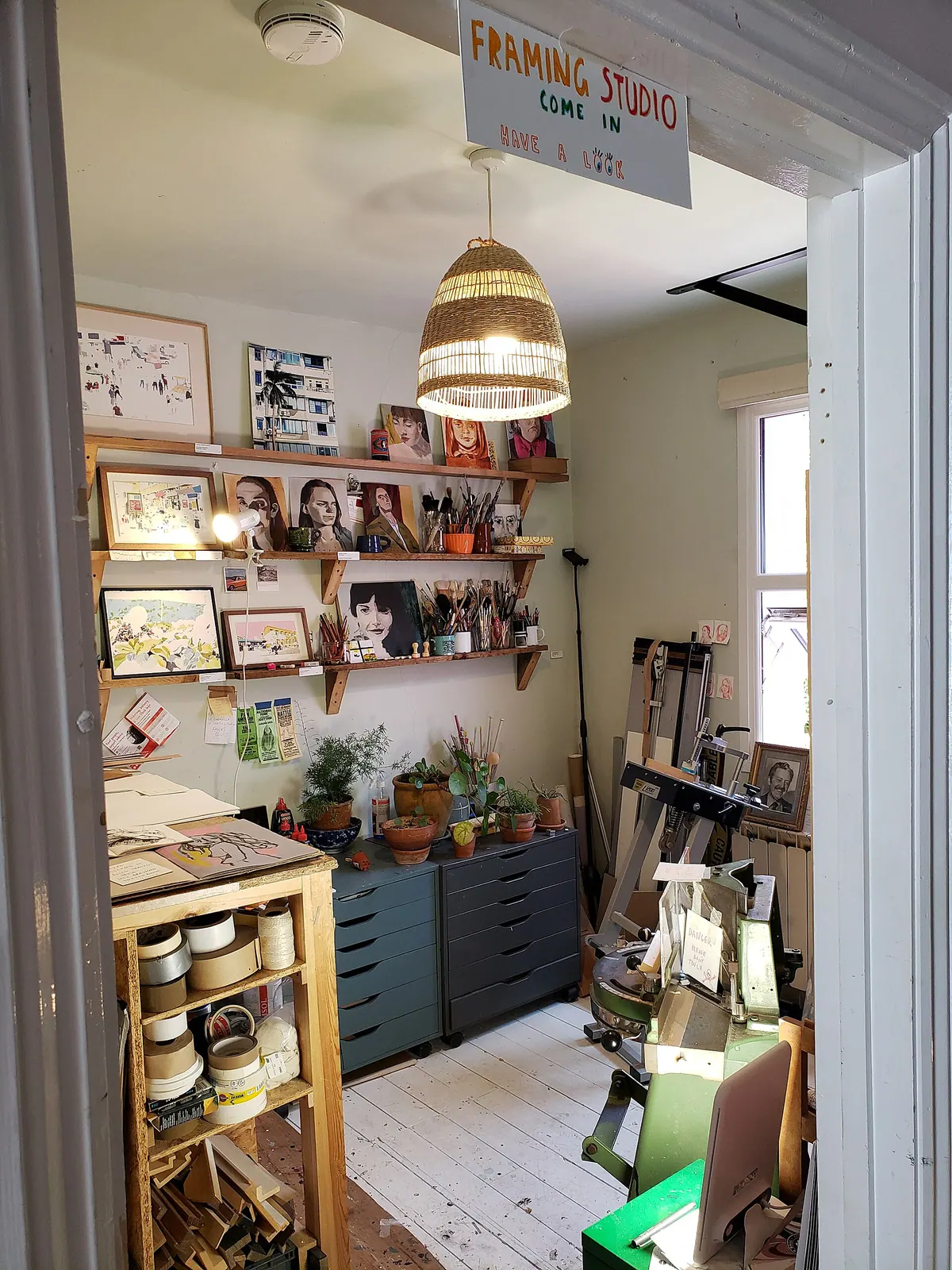 A quiet studio room with framed work on the walls
